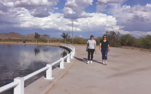 Two Women Walk Along a Lake