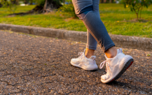 A close-up of a woman's sneakers on a paved path, walking for weight loss, symbolizing the start of an outdoor weight loss routine in Arizona during fall.