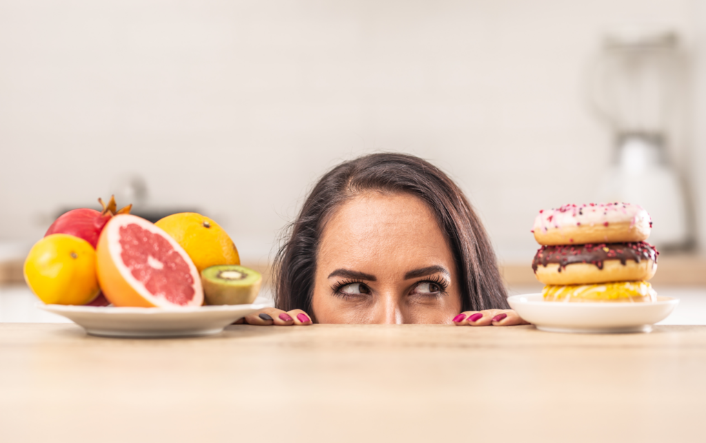 A woman staring at a plate of food that could sabotage her weight loss