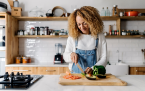 Woman making healthy meal in kitchen to reverse menopausal belly fat